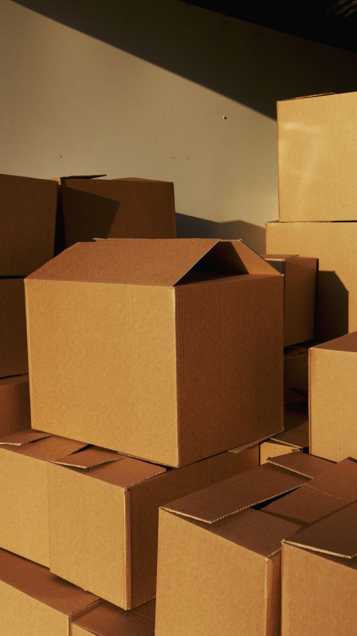 gallery-2 Stacked cardboard boxes ready for shipping or storage in a warehouse setting.