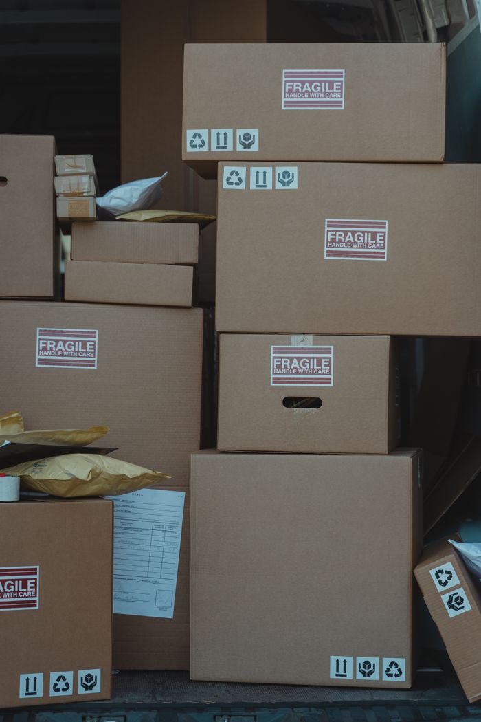services-img Vertical stack of cardboard boxes labeled 'fragile' for shipping and storage.