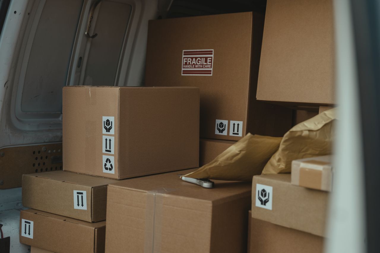 gallery-6 Neatly organized cardboard boxes inside a delivery van, ready for shipment.